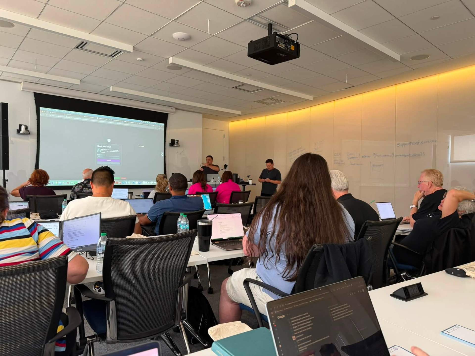 Wide view of the training room with the CRM walkthrough on screen