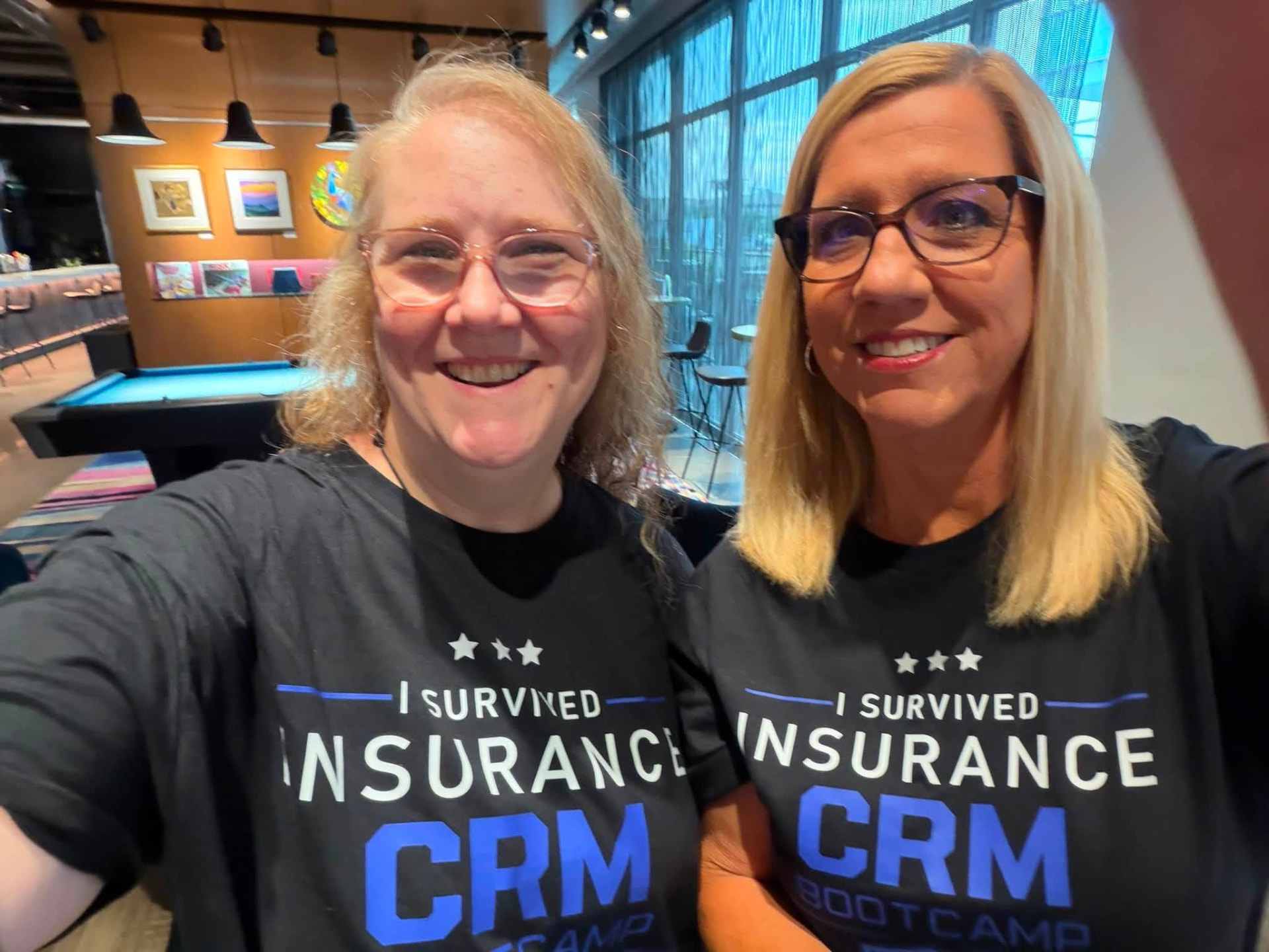 Two attendees in 'I Survived Insurance CRM Bootcamp' shirts
